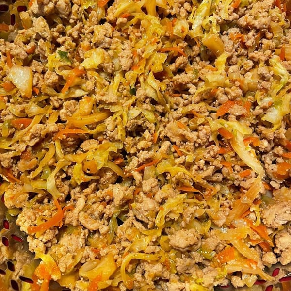 Close-up of Blasian Fusion's egg roll in a bowl, featuring ground meat, shredded cabbage, and carrots.