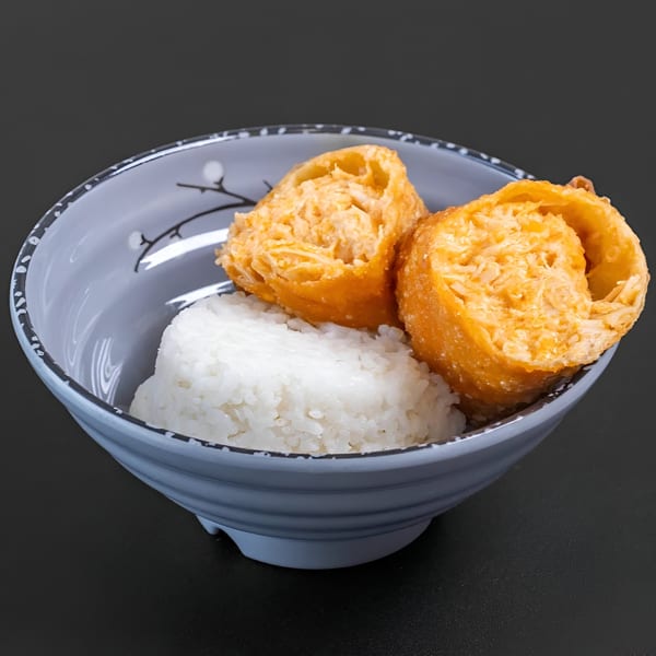 Two golden-fried Blasian Fusion egg rolls with white rice in a decorative bowl.